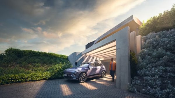 man walking around the car park underneath the arch