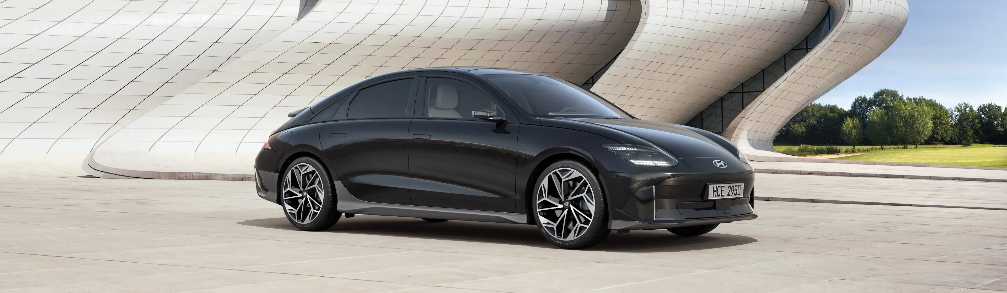 car parked otuside building grass in the distance