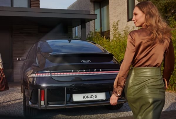 lady looking around in front of the car