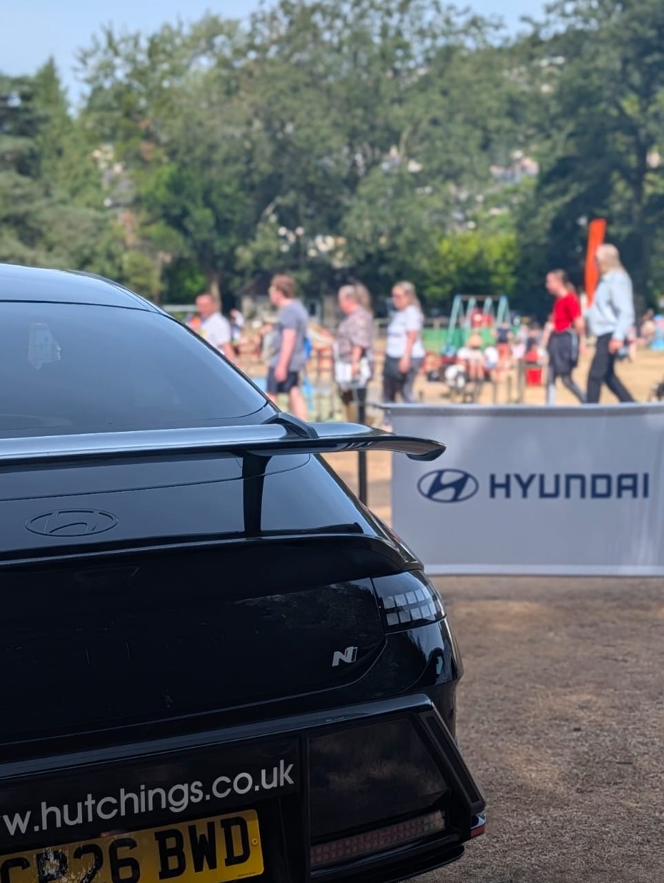 Back of a black Hyundai car with a UK number plate CP26 BWD at an outdoor event.