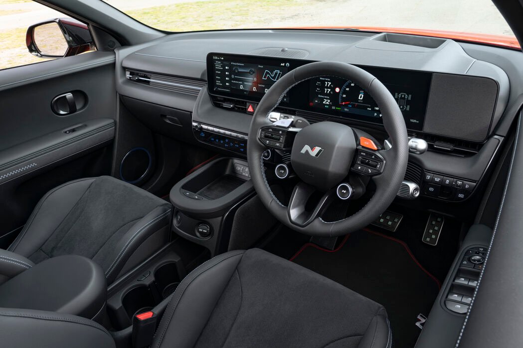 Car interior with digital dashboard and multifunction steering wheel.