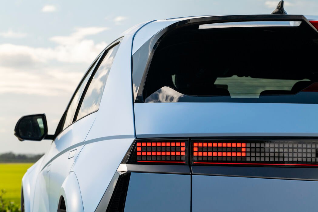 Rear view of a modern car with illuminated rear lights.