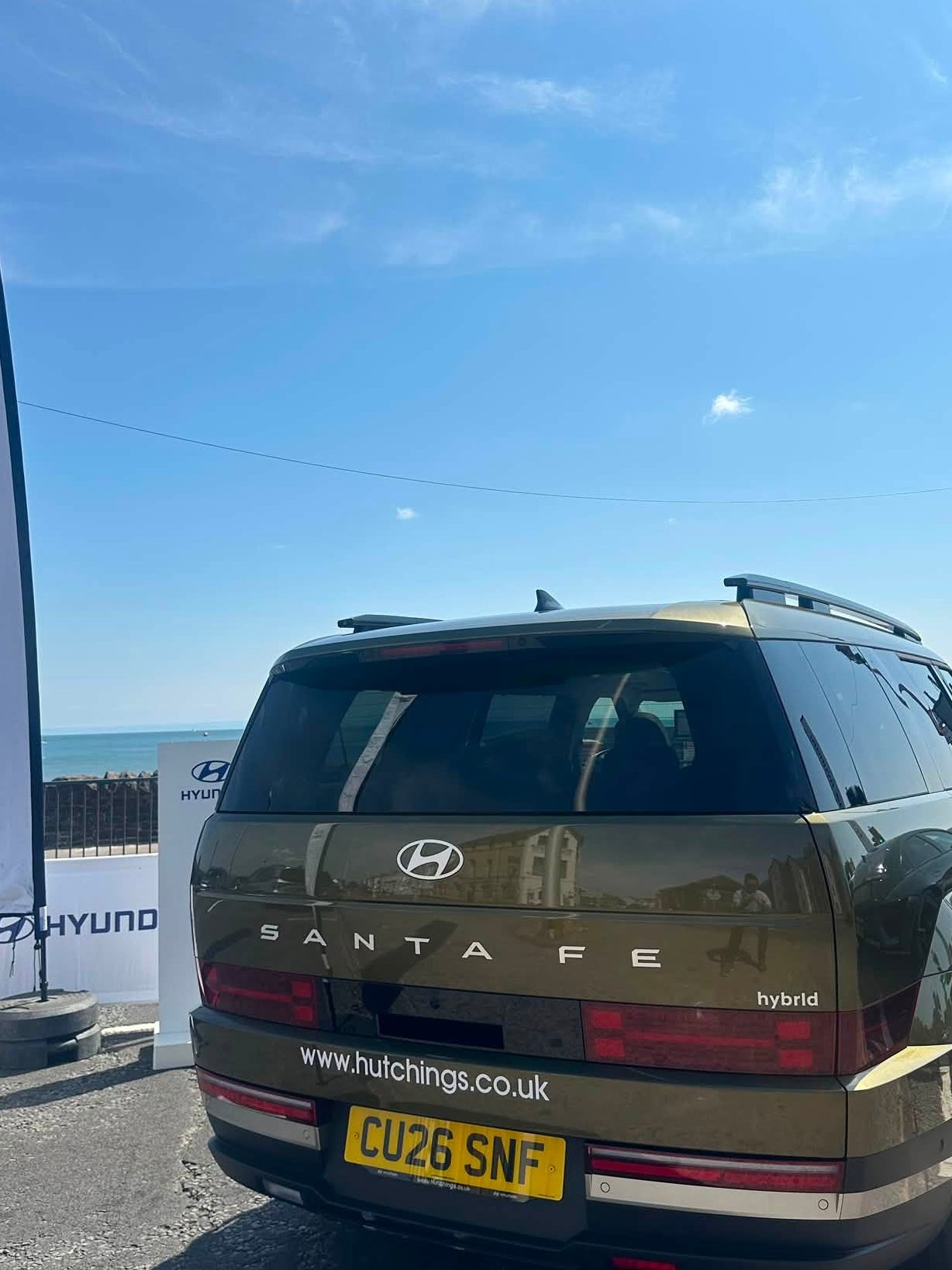 Rear view of a Hyundai Santa Fe hybrid with visible registration plate CU26 SNF.