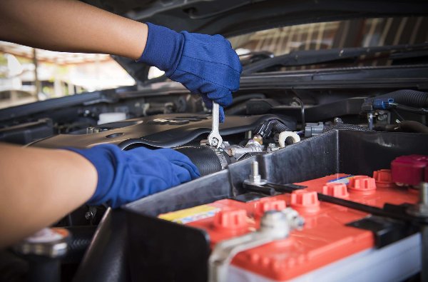 person fixing the car underneath the engine